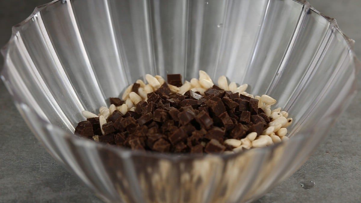 Glass bowl filled with rice bits and chunks of chocolate