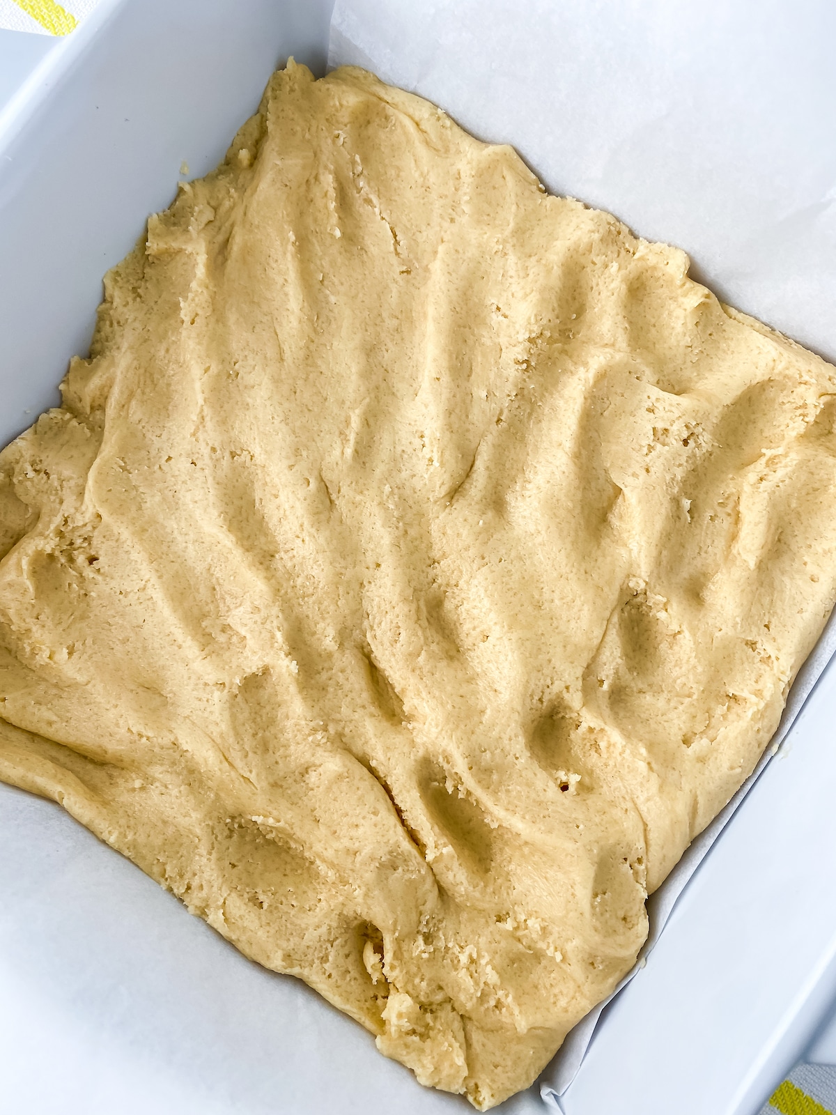 Cookie dough pressed into baking sheet before baking