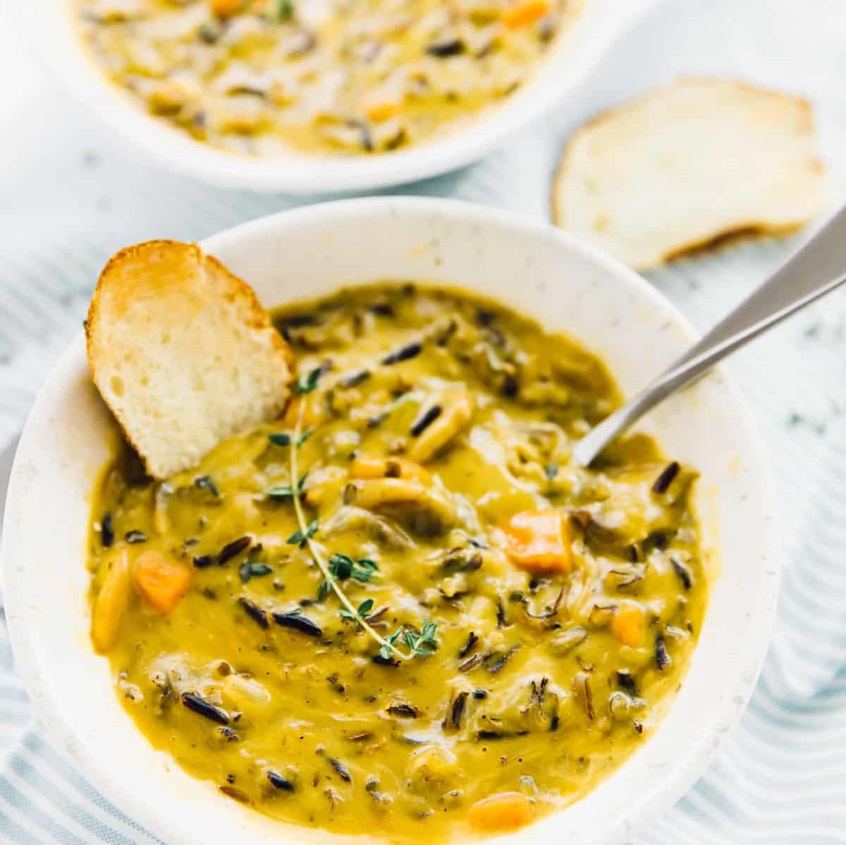 Vegan mushroom wild rice soup served with a slice of bread