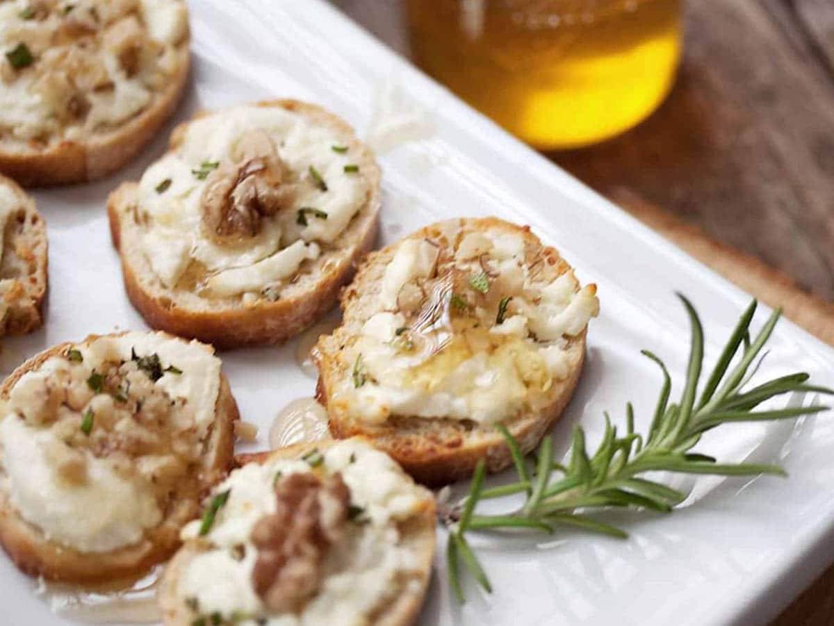 Warm Goats Cheese Toasts topped with crushed walnuts and finely chopped rosemary