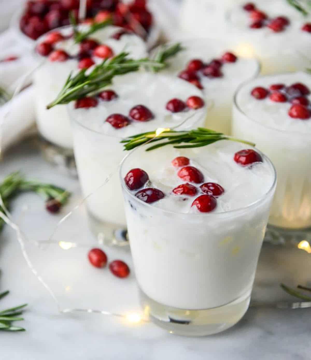 White Christmas Margarita Punch garnished with pomegranate seeds and rosemary