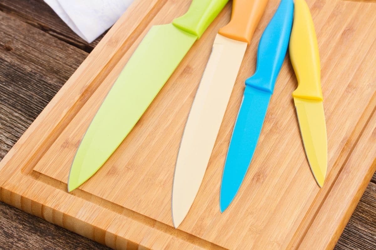 Colorful Ceramic Knives on Wooden Board