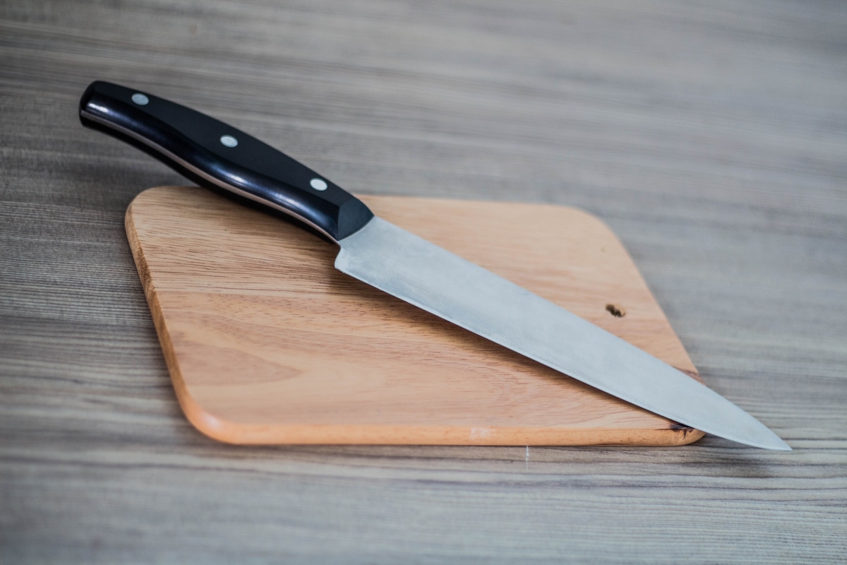 Chef's knife and Chopping board on wood table.