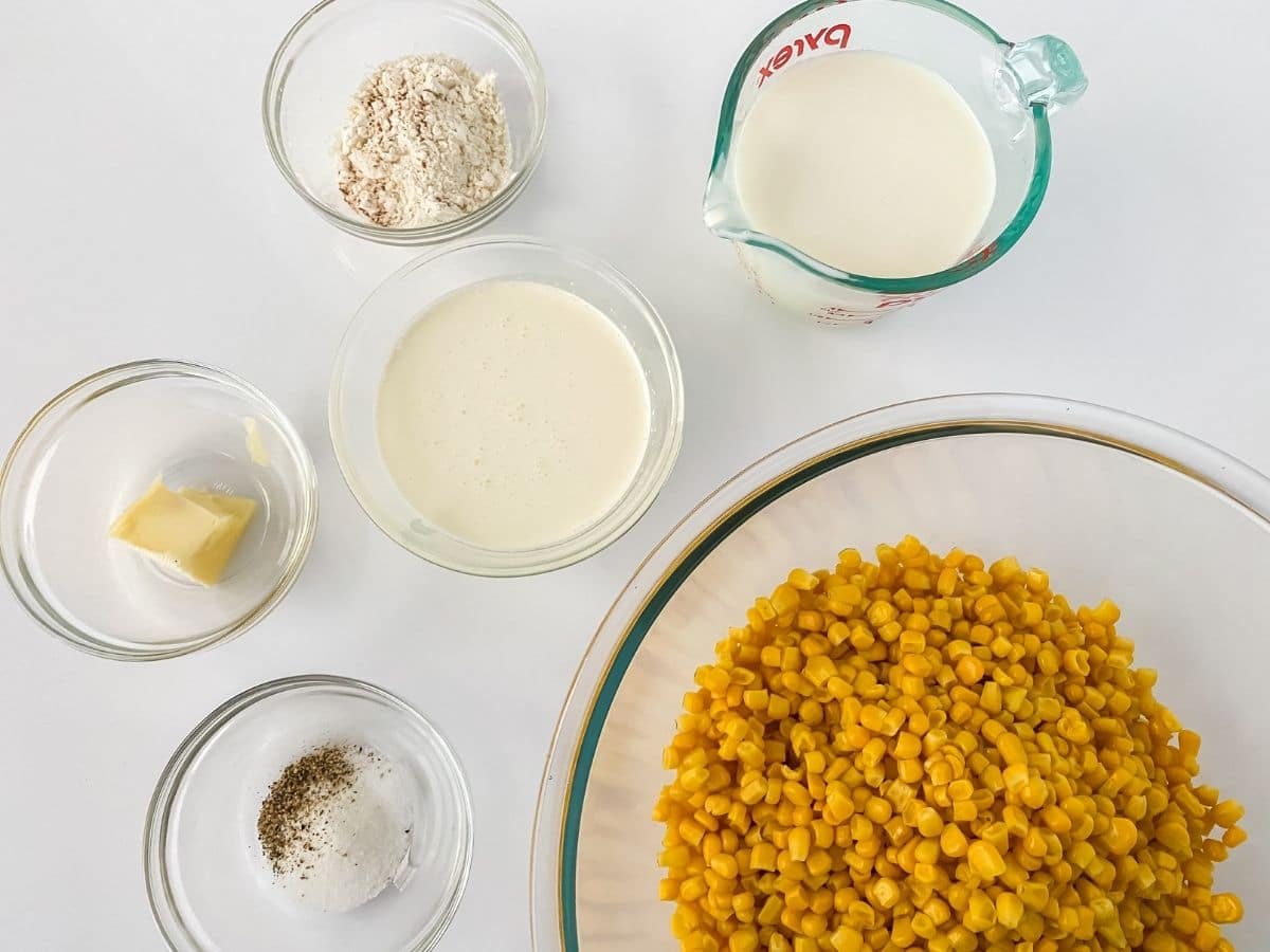 Ingredients for creamed corn in glass bowls on white table
