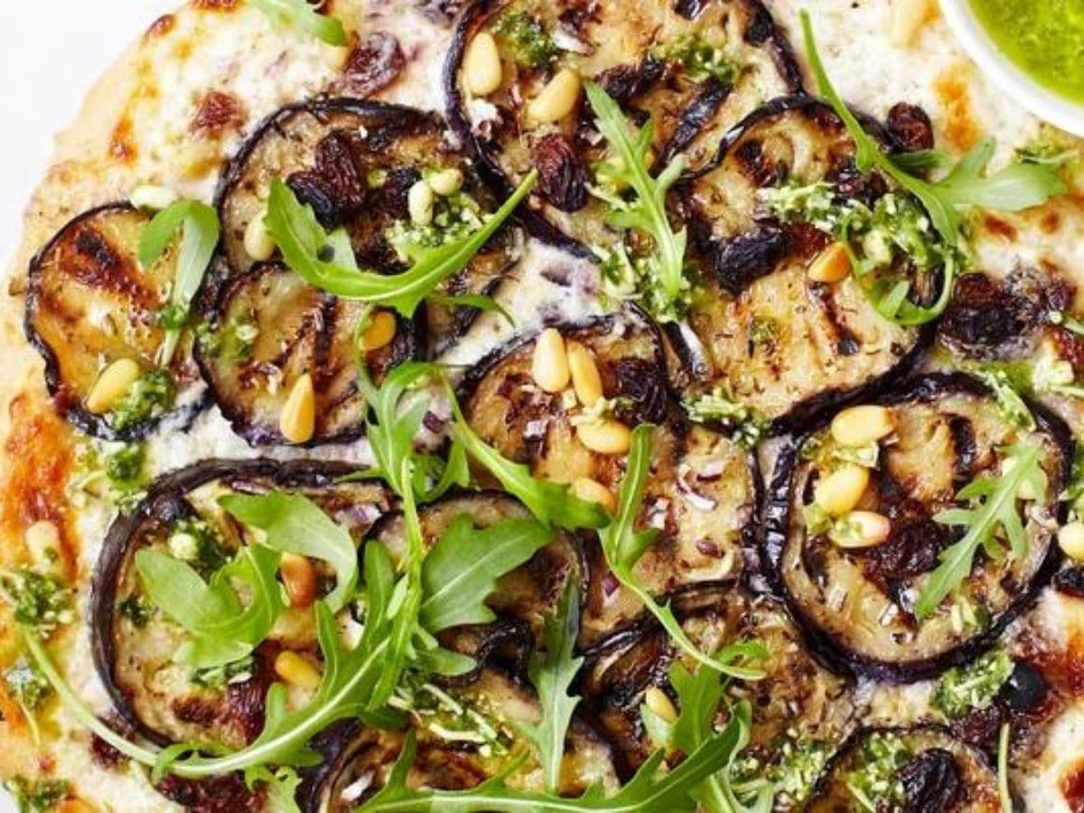 pizza topped with eggplant and arugala