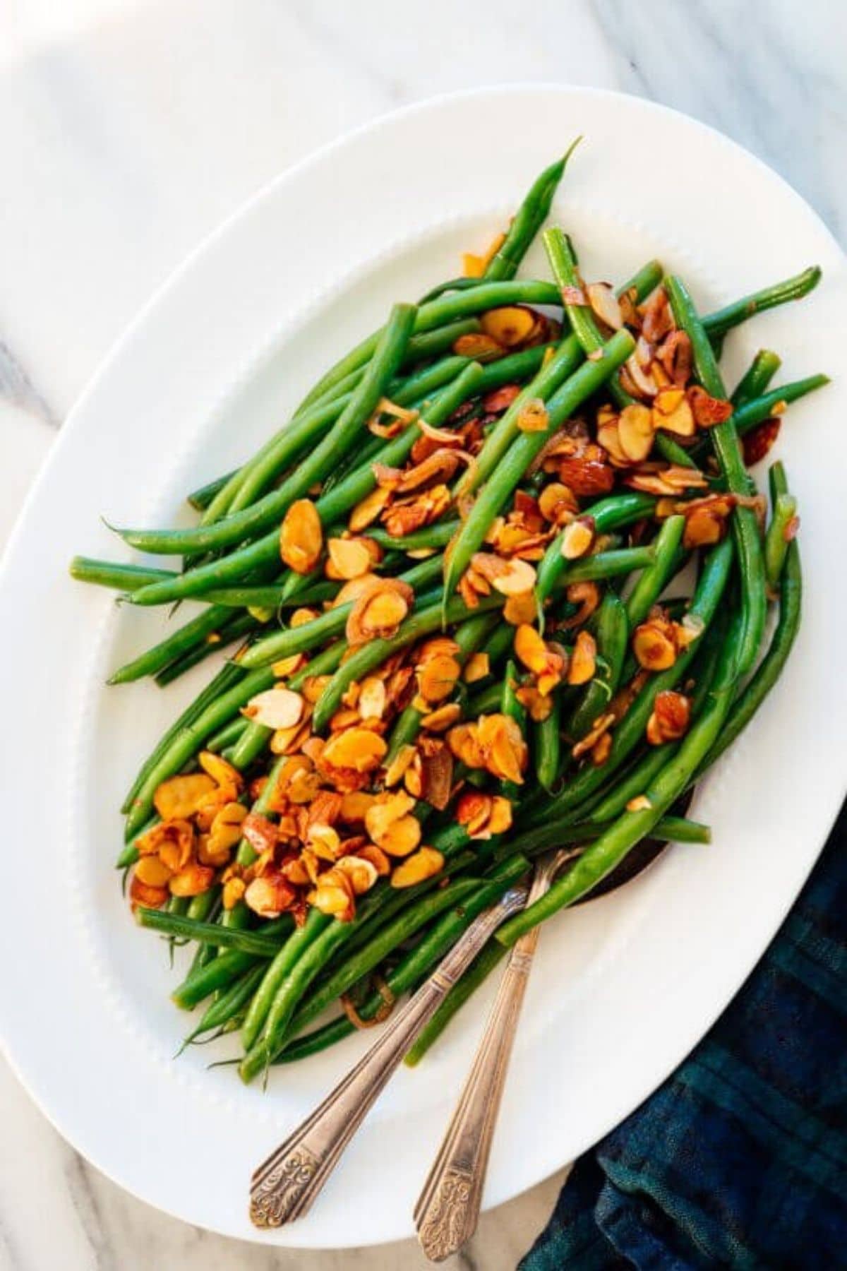 oval white platter filled with green beans and almonds