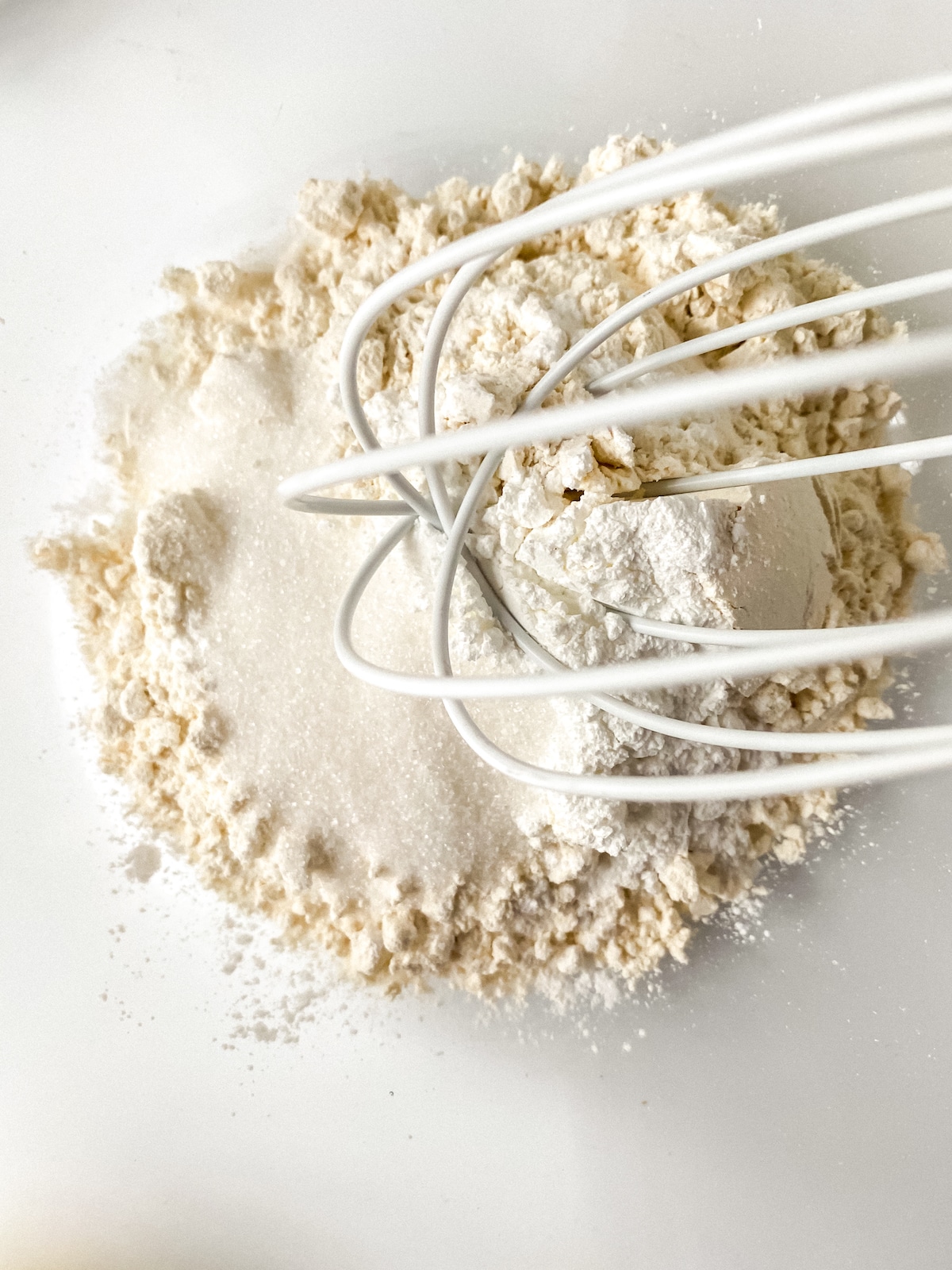 White whisk in bowl of flour and salt