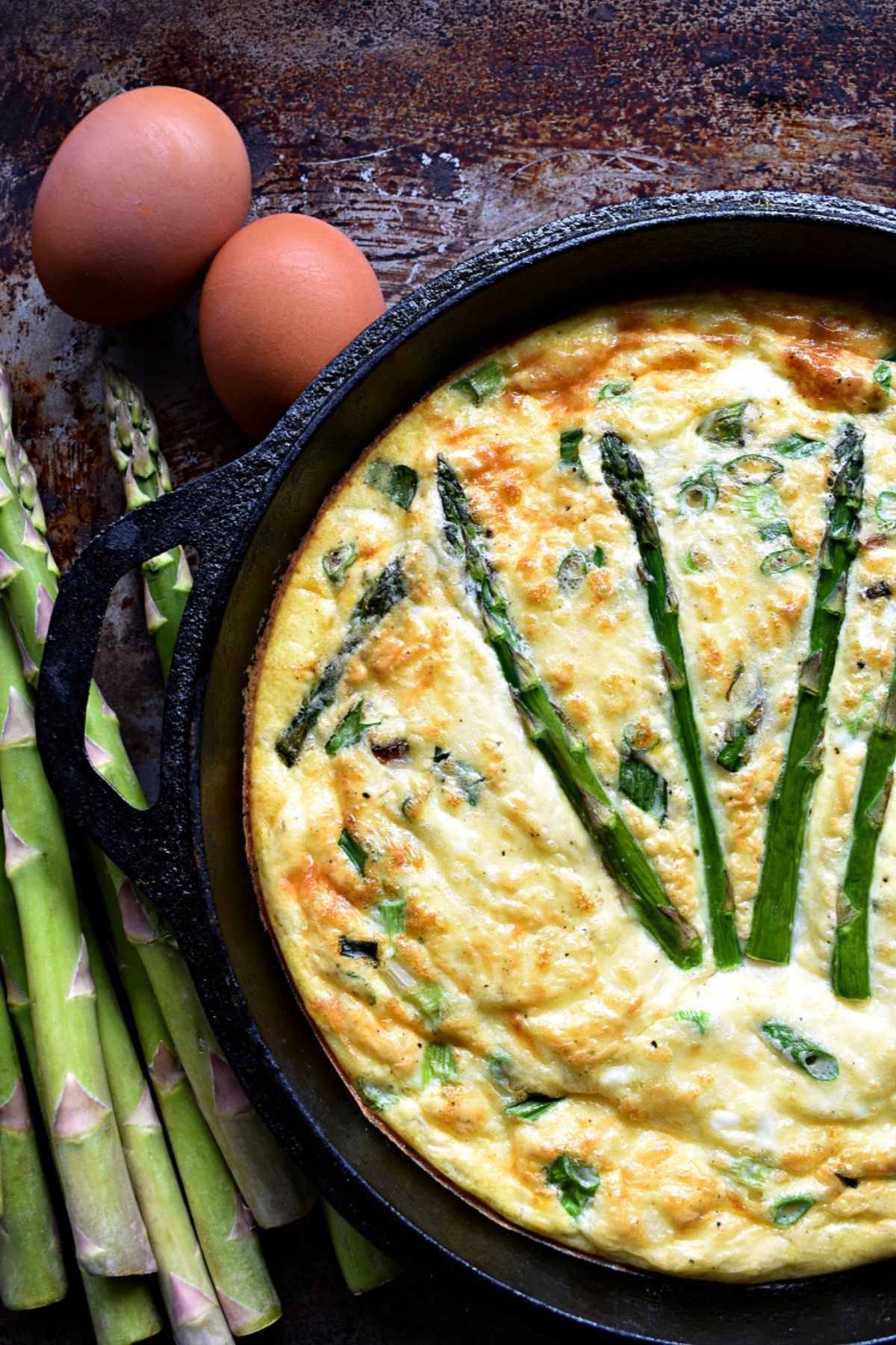 Cast iron skillet with asparagus in eggs