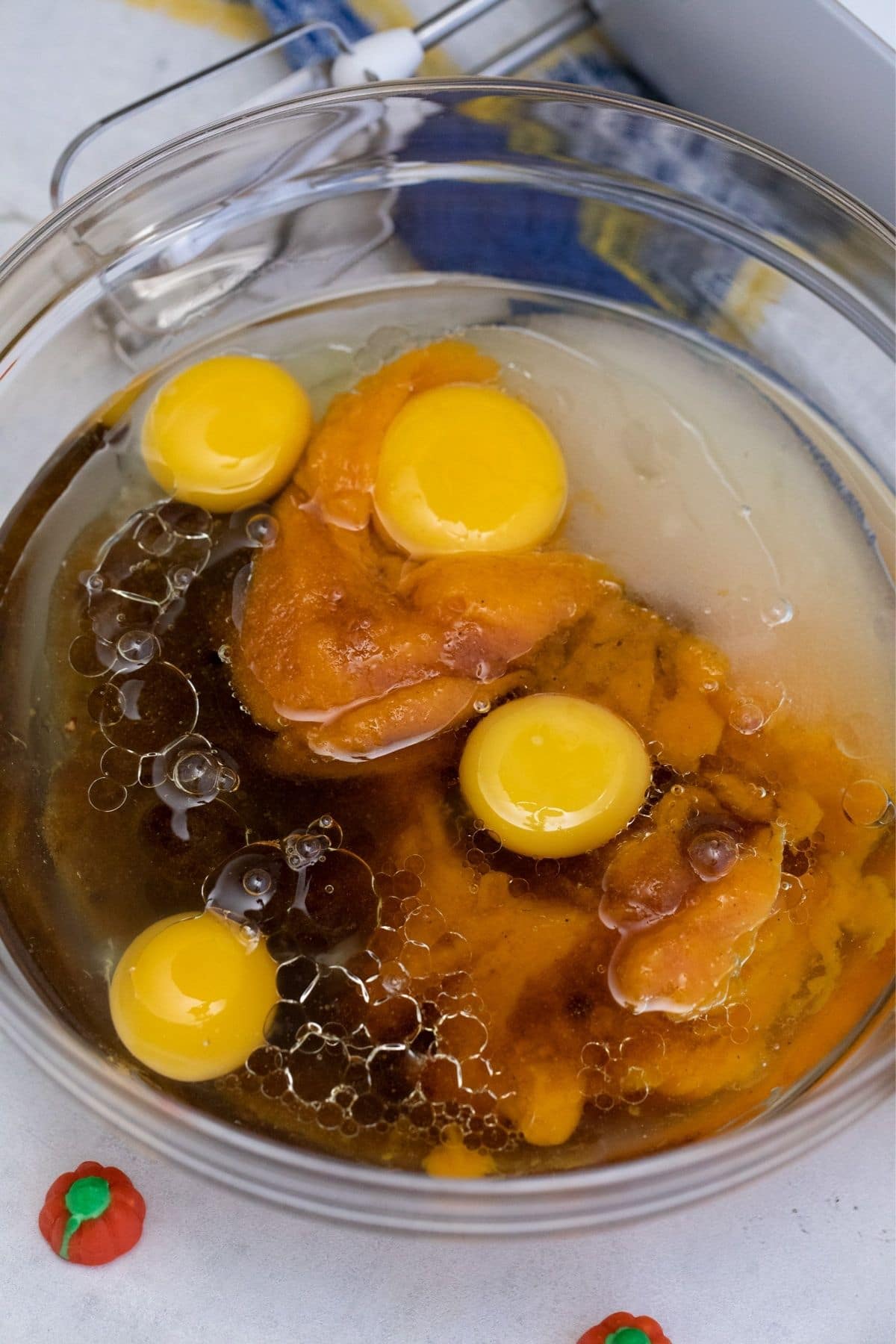 Large glass bowl of pumpkin puree eggs and oil