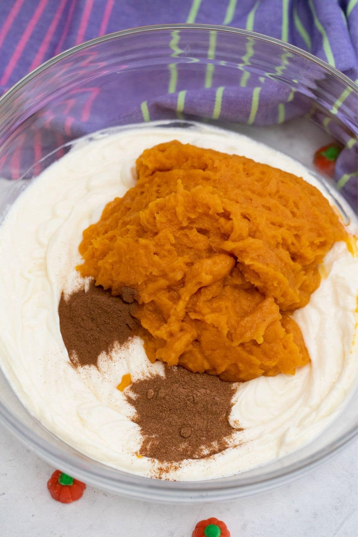 Large glass bowl of cream cheese with pumpkin and spice on top
