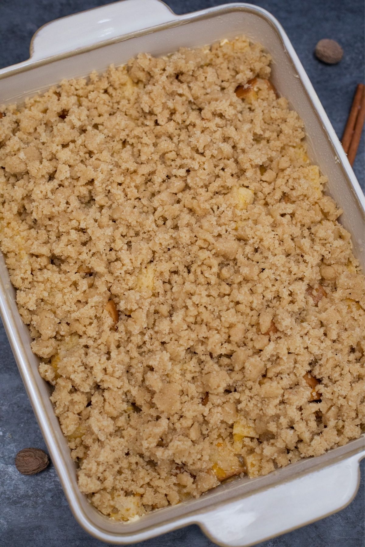 White baking dish with unbaked casserole topped with streusel