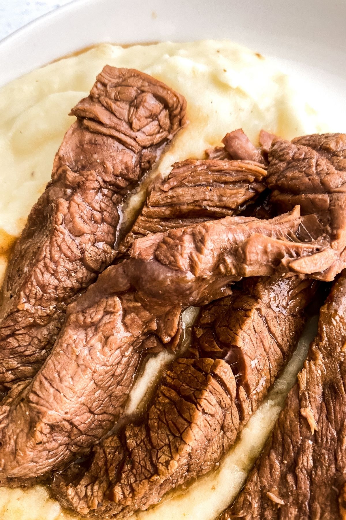 Steak slices in bowl with mashed potatoes