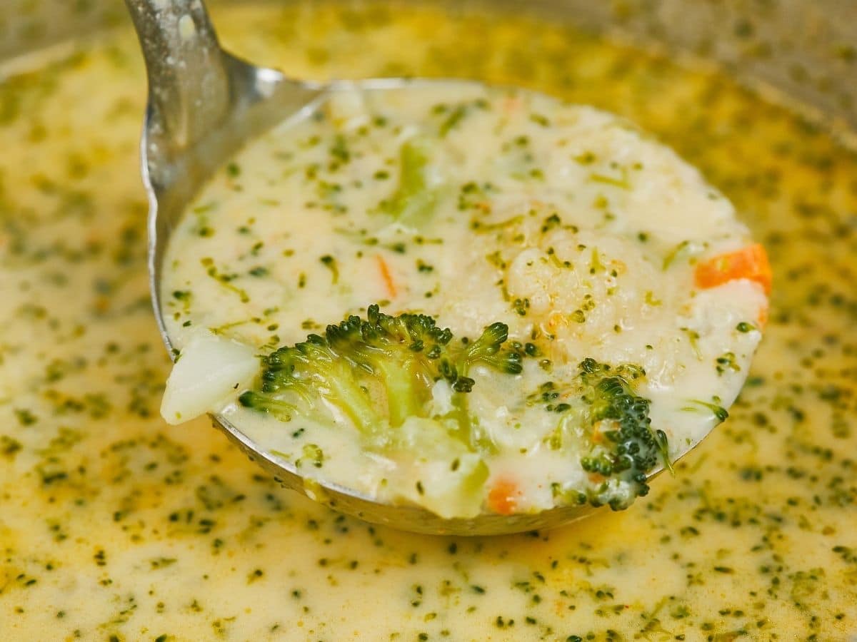 Dutch oven with spoon of broccoli cheese soup