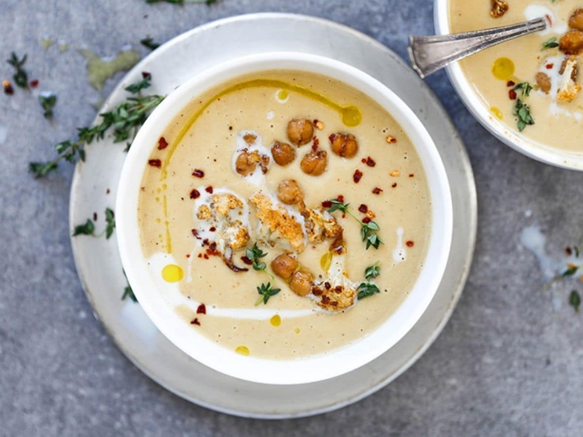 cauliflower soup in white bowl on gray table