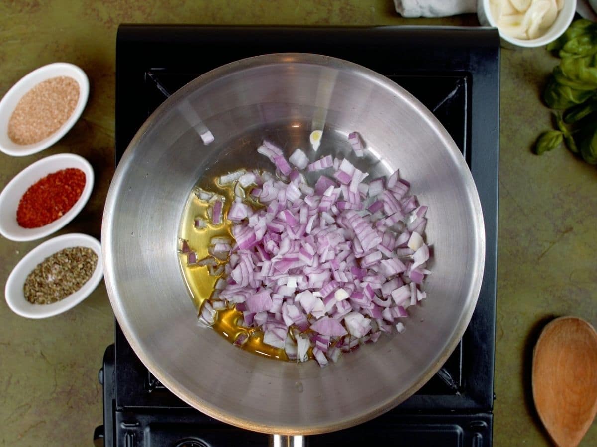 Red onions in stainless steel skillet on hot plate