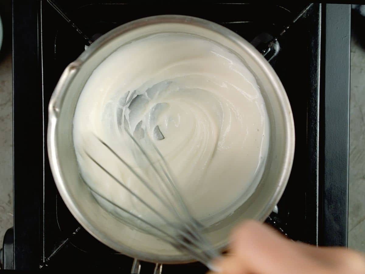 saucepan of flour and milk with whisk