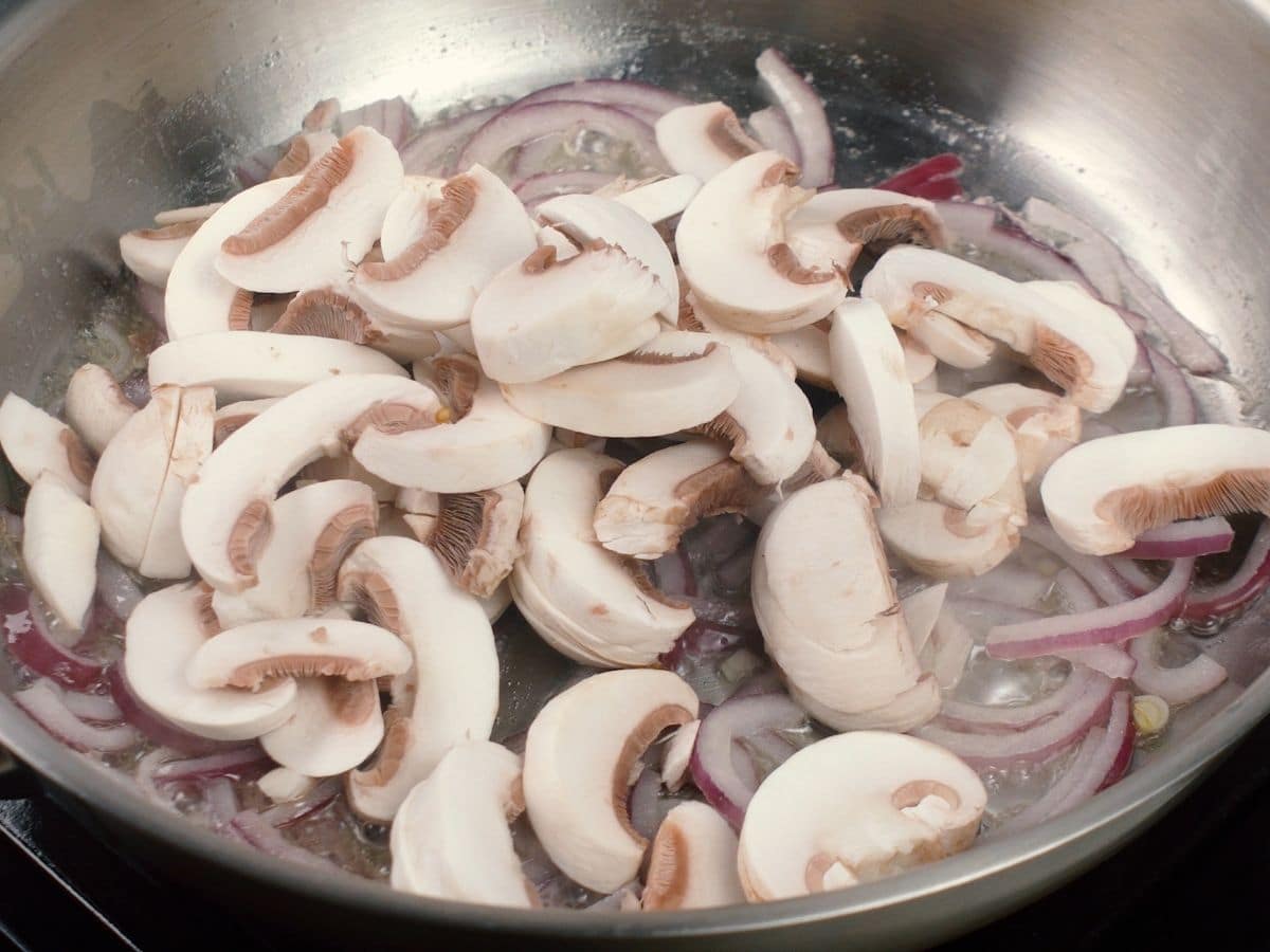 Mushrooms and onions cooking in skillet