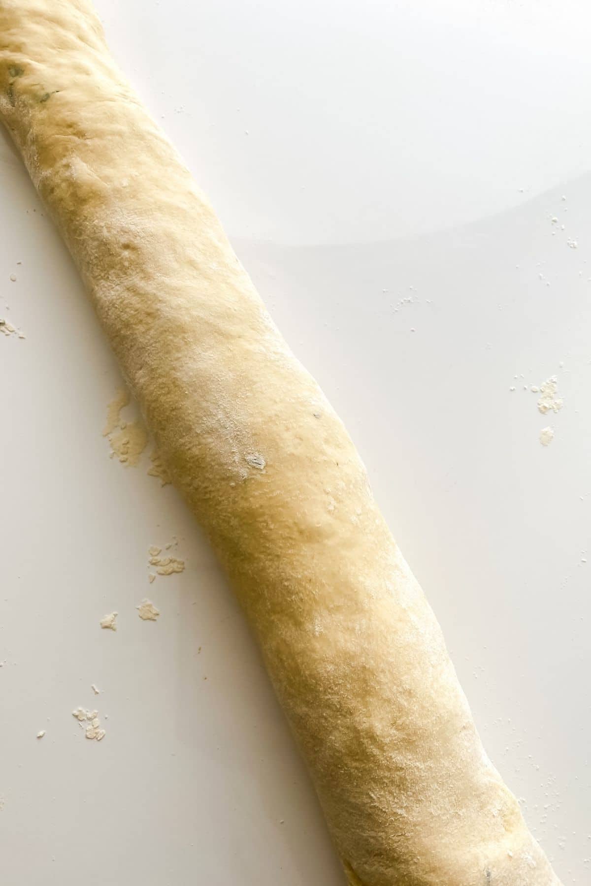 roll of bread dough on white counter