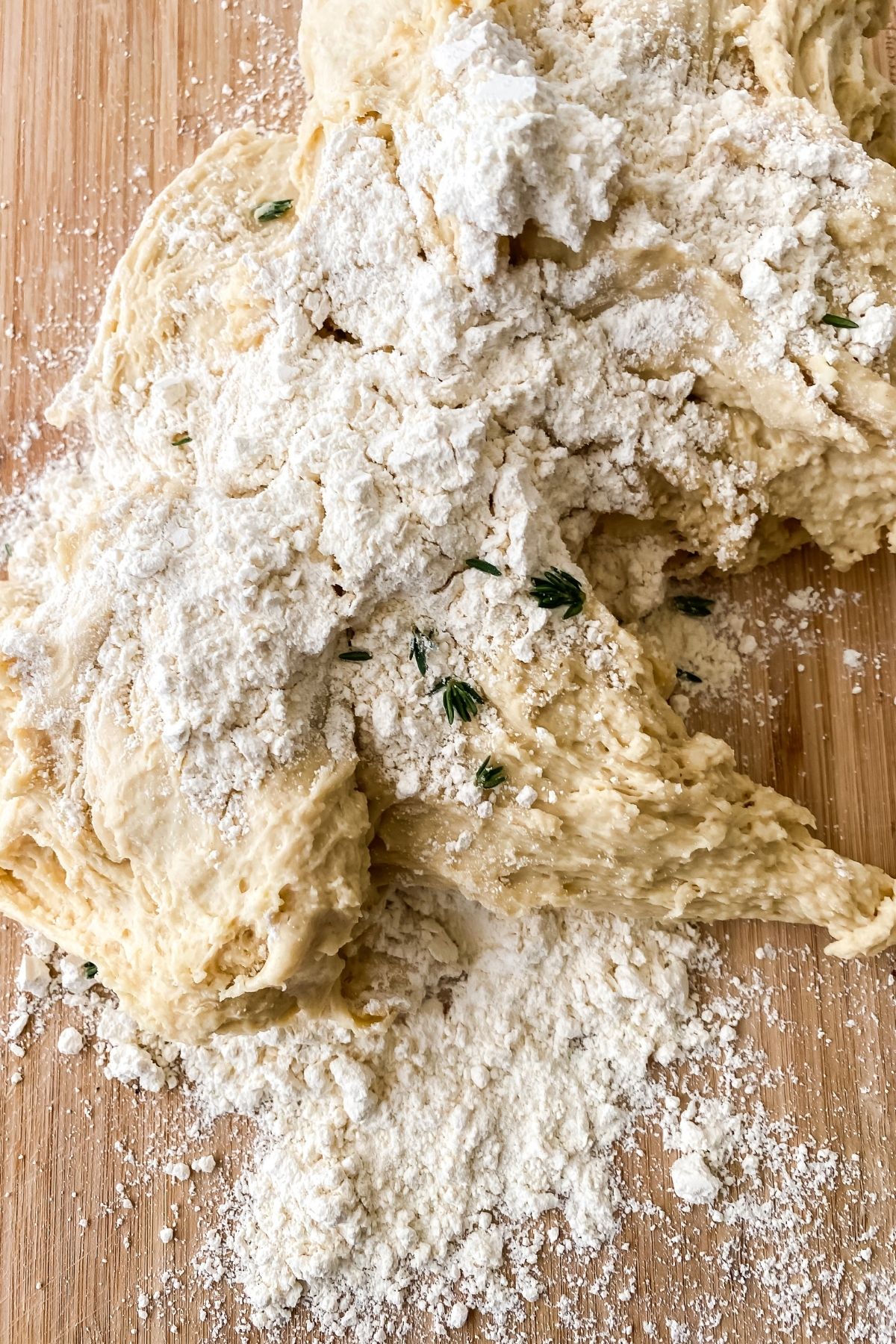 bread dough with herbs on cutting board