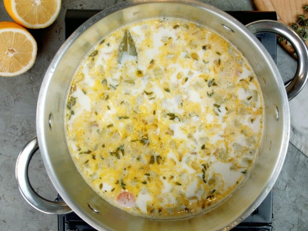Creamy soup with yellow tint in large stockpot on hot plate