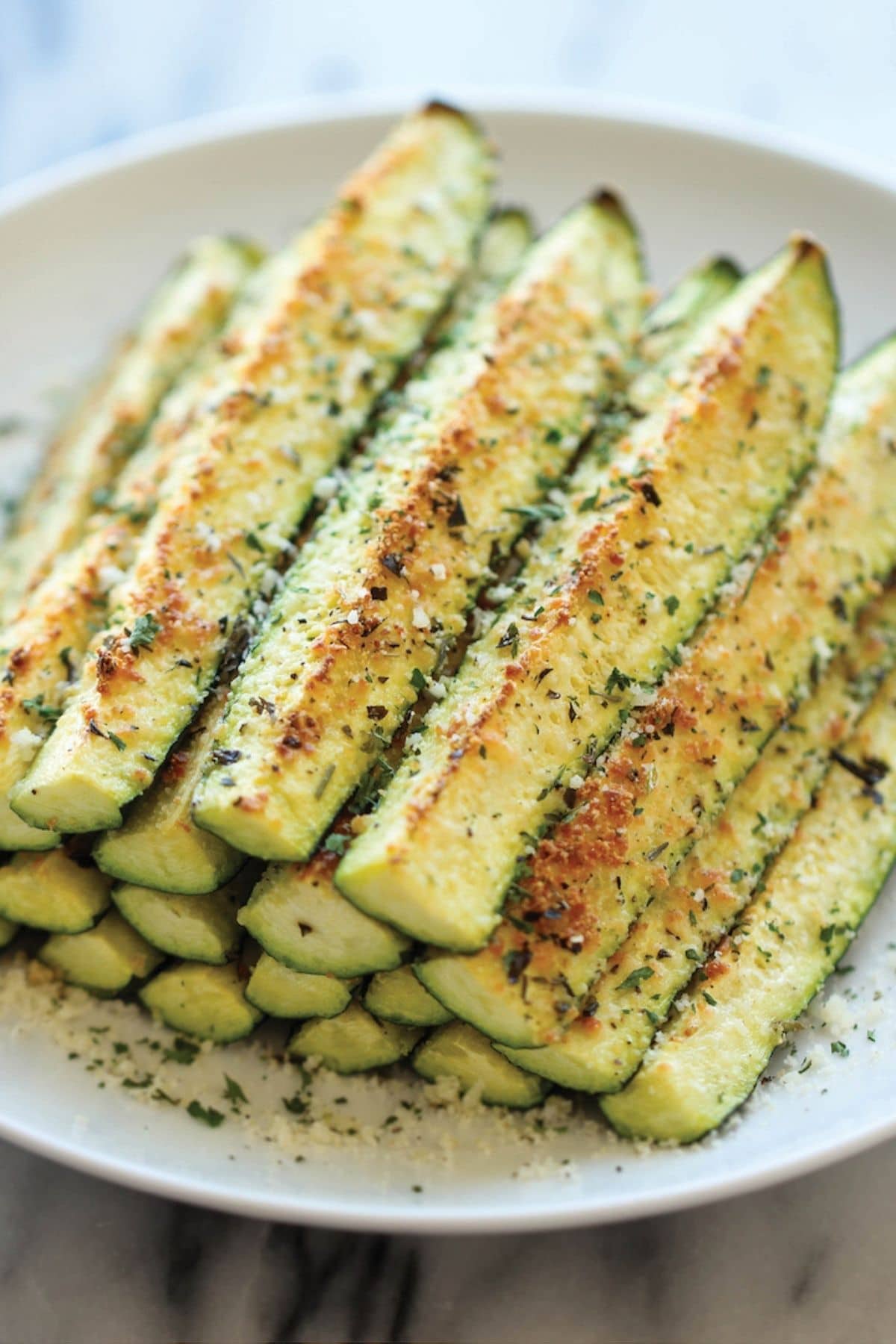 Plate of zucchini spears with parmesan and herbs