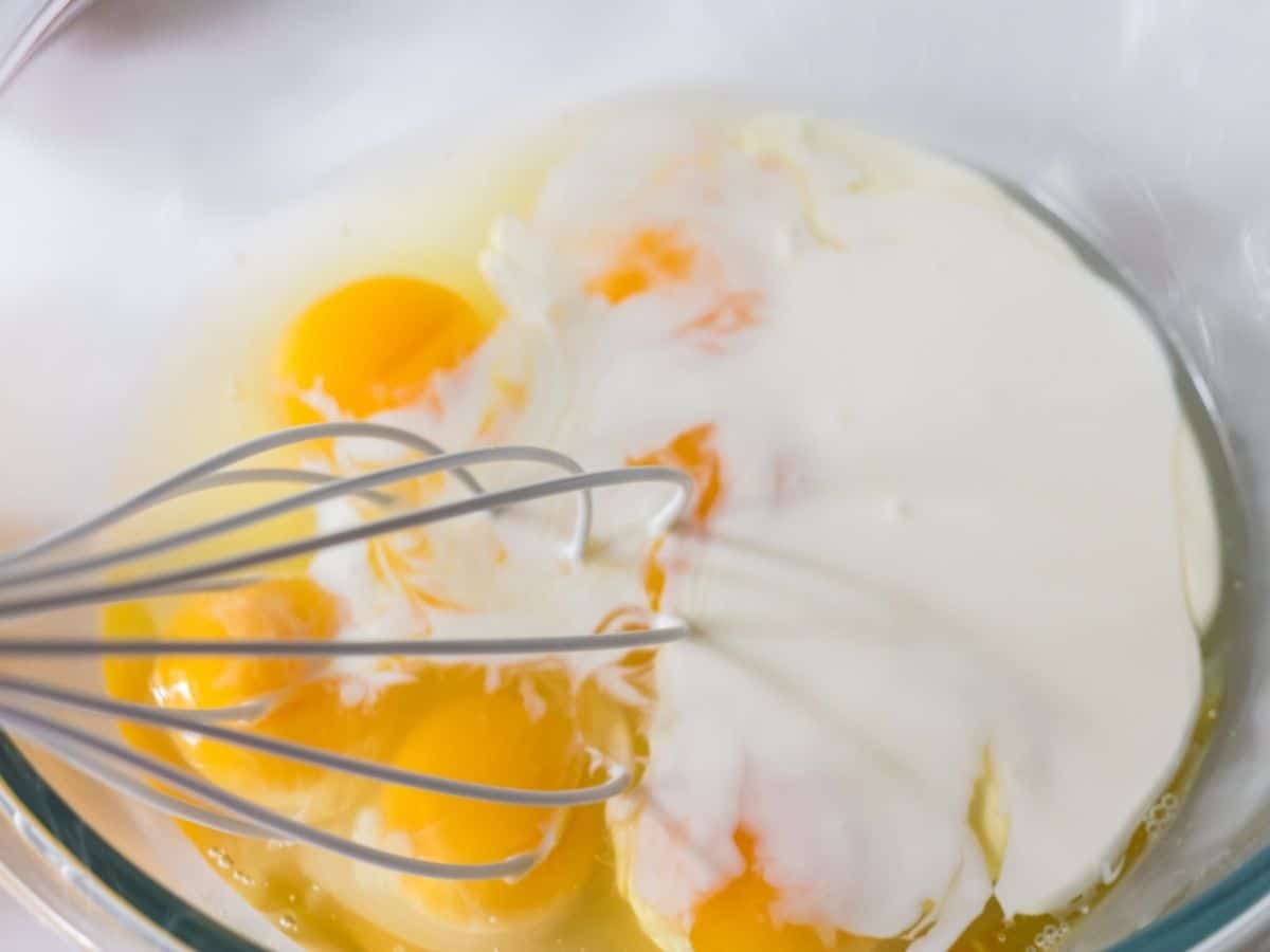 whisk in glass bowl with egg and milk