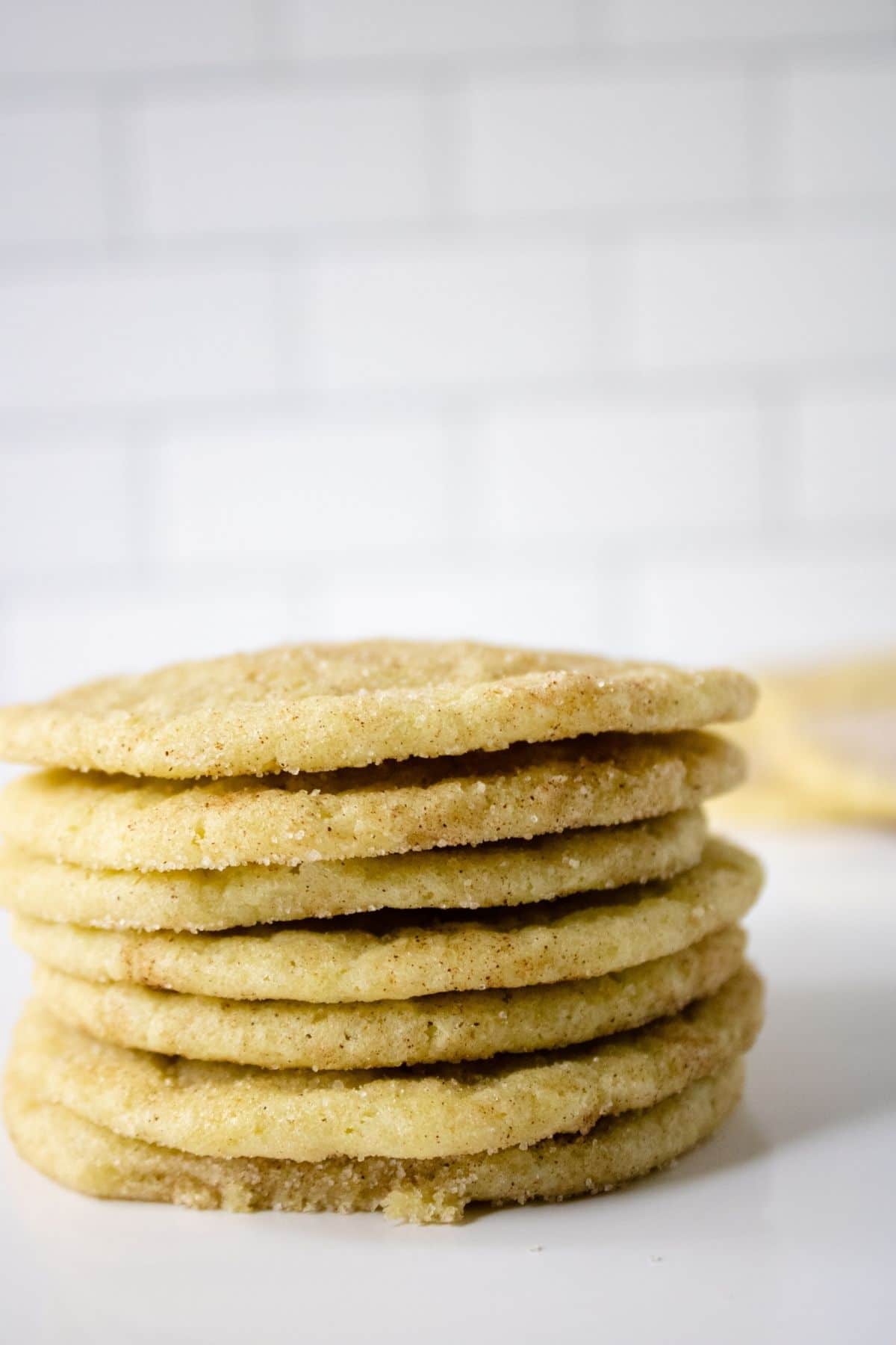 stack of matcha snickerdoodle cookies on white table in front of white tile