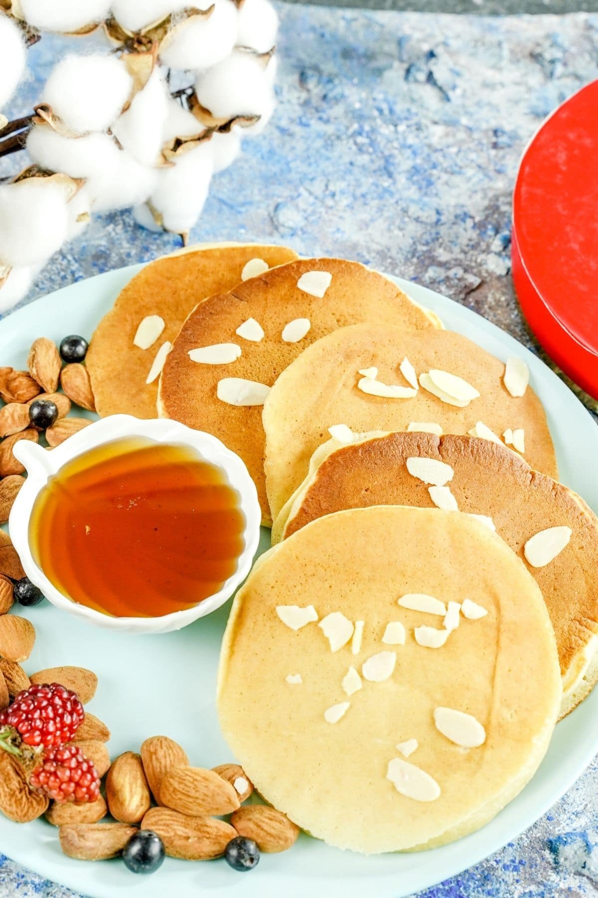 pancakes topped with nuts and honey on blue plate on marble counter