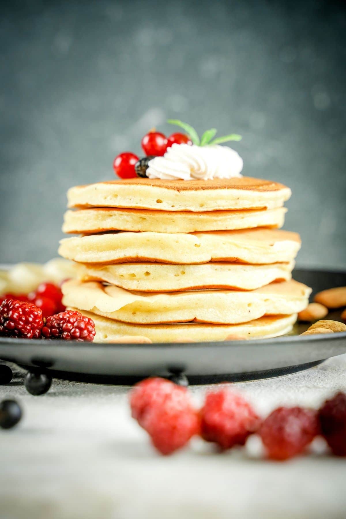 stack of pancakes on gray plate with gray background