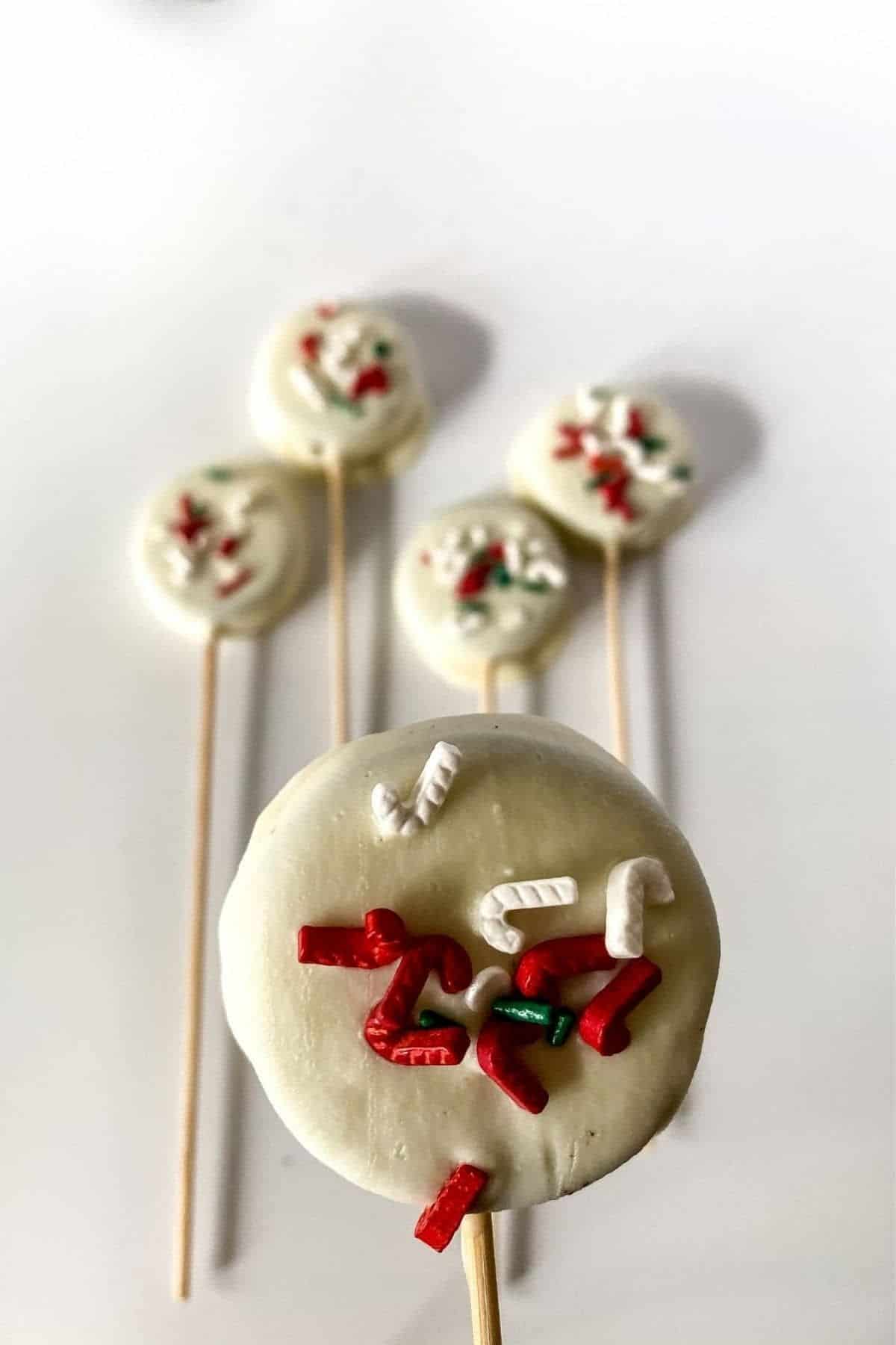 oreo pops with white chocolate and candy cane sprinkles