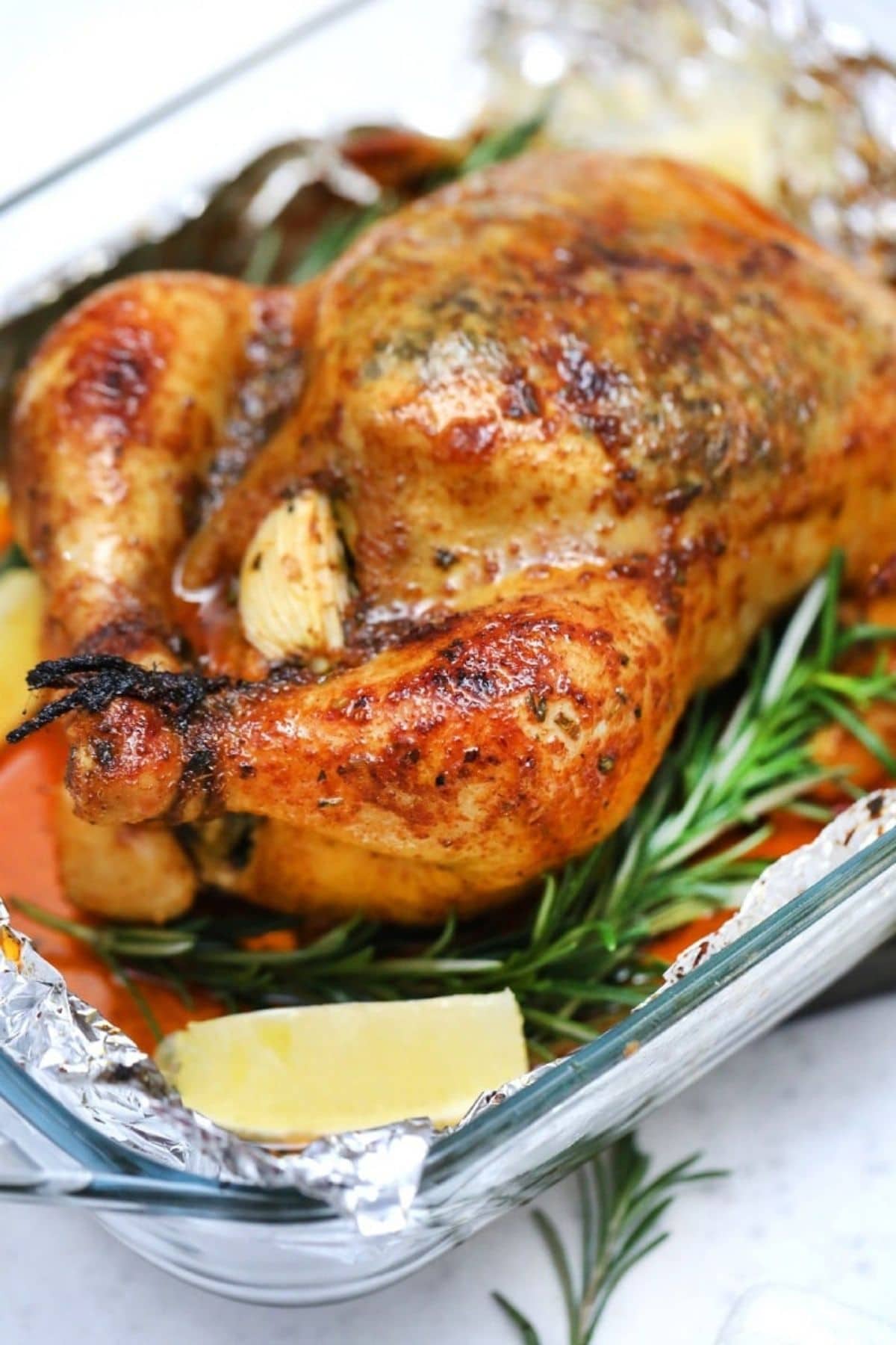 roasted chicken in silver platter with lemon wedge on side