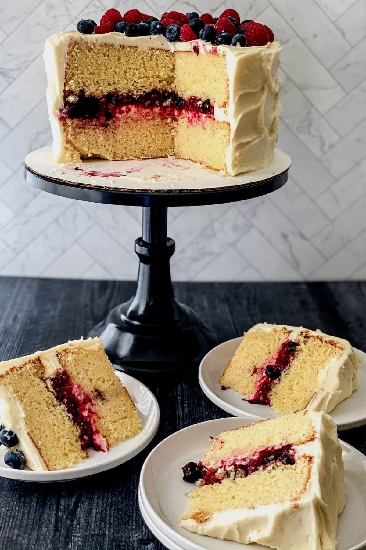 layer cake with berry filling on black cake stand