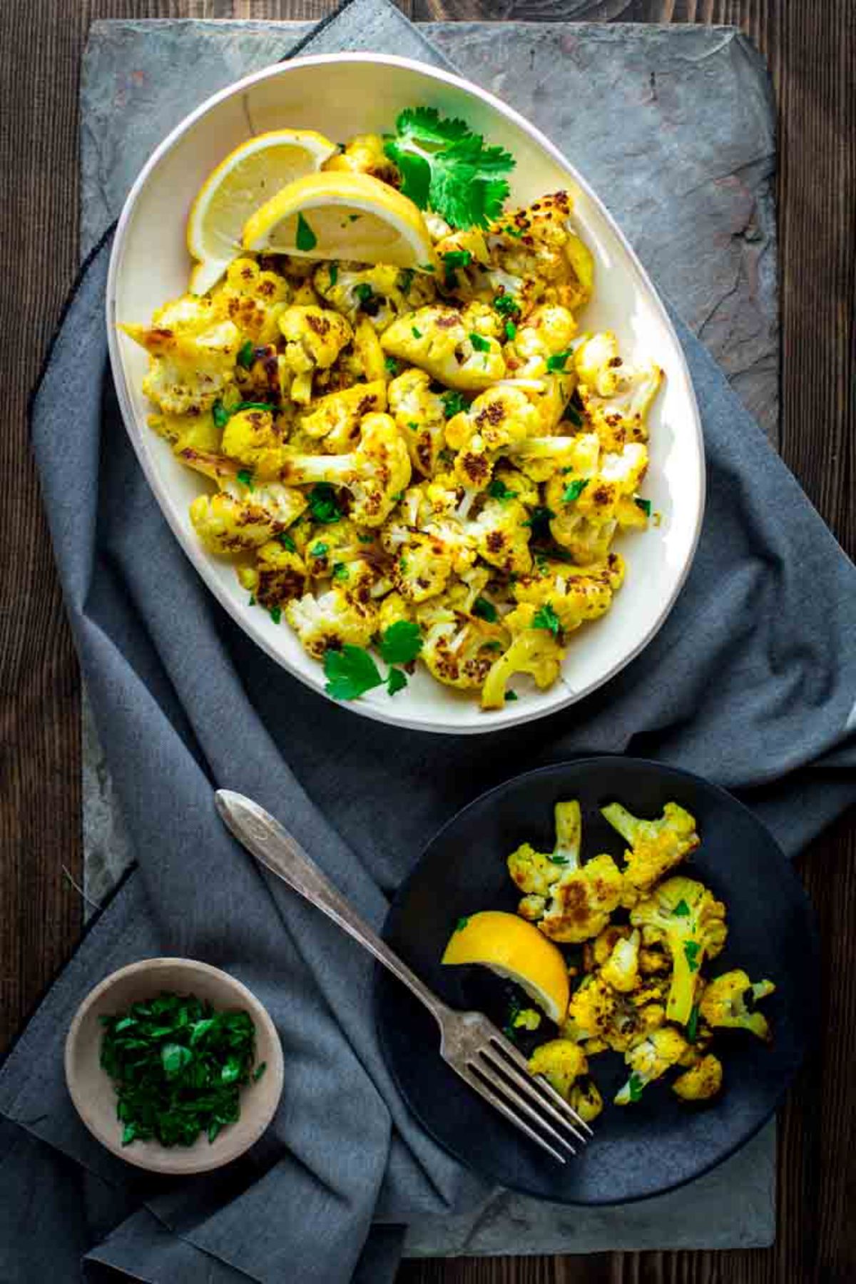 white platter of curry cauliflower on gray tablecloth