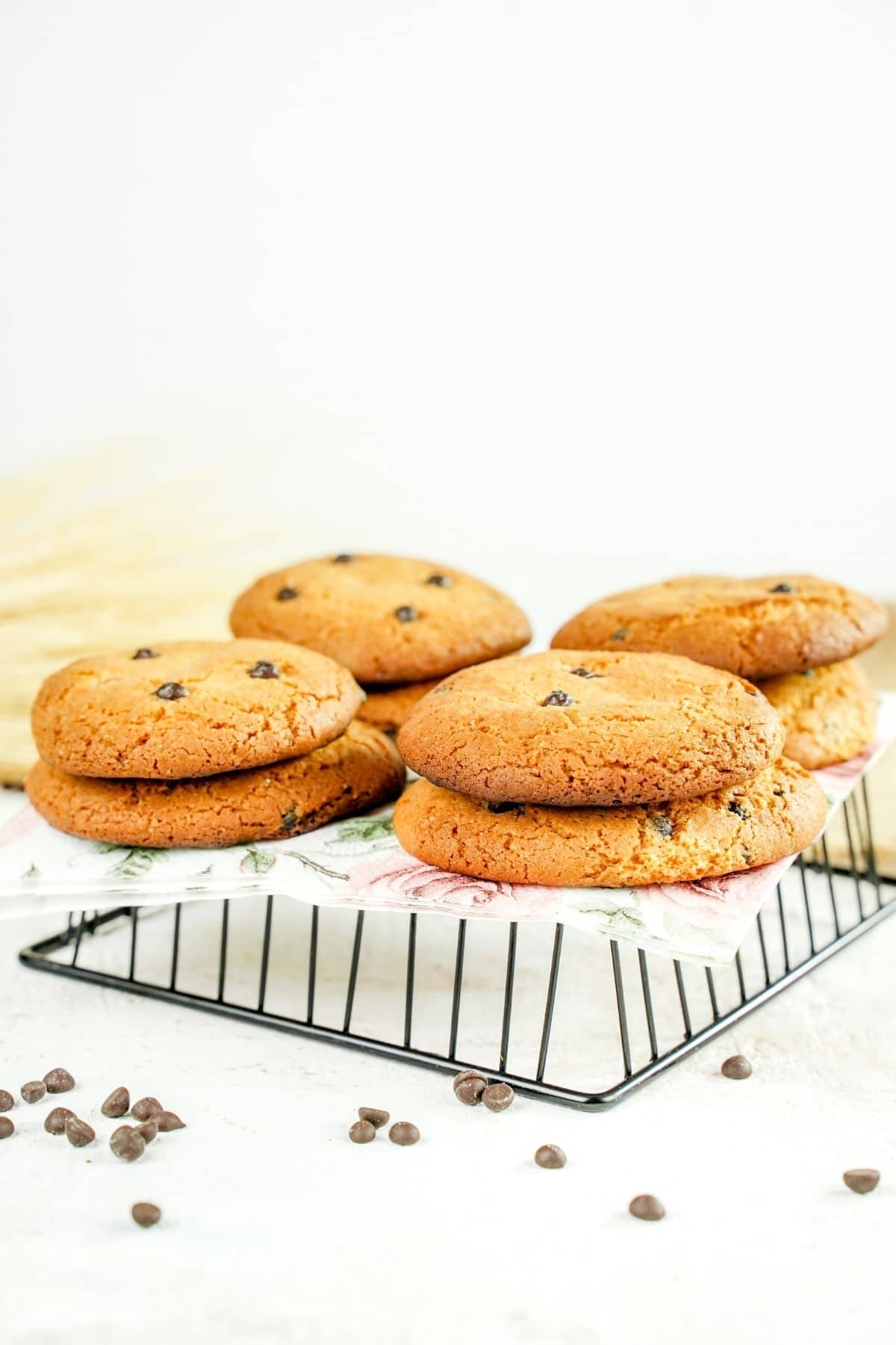 stacks of chocolate chip cookies on paper on wire rack