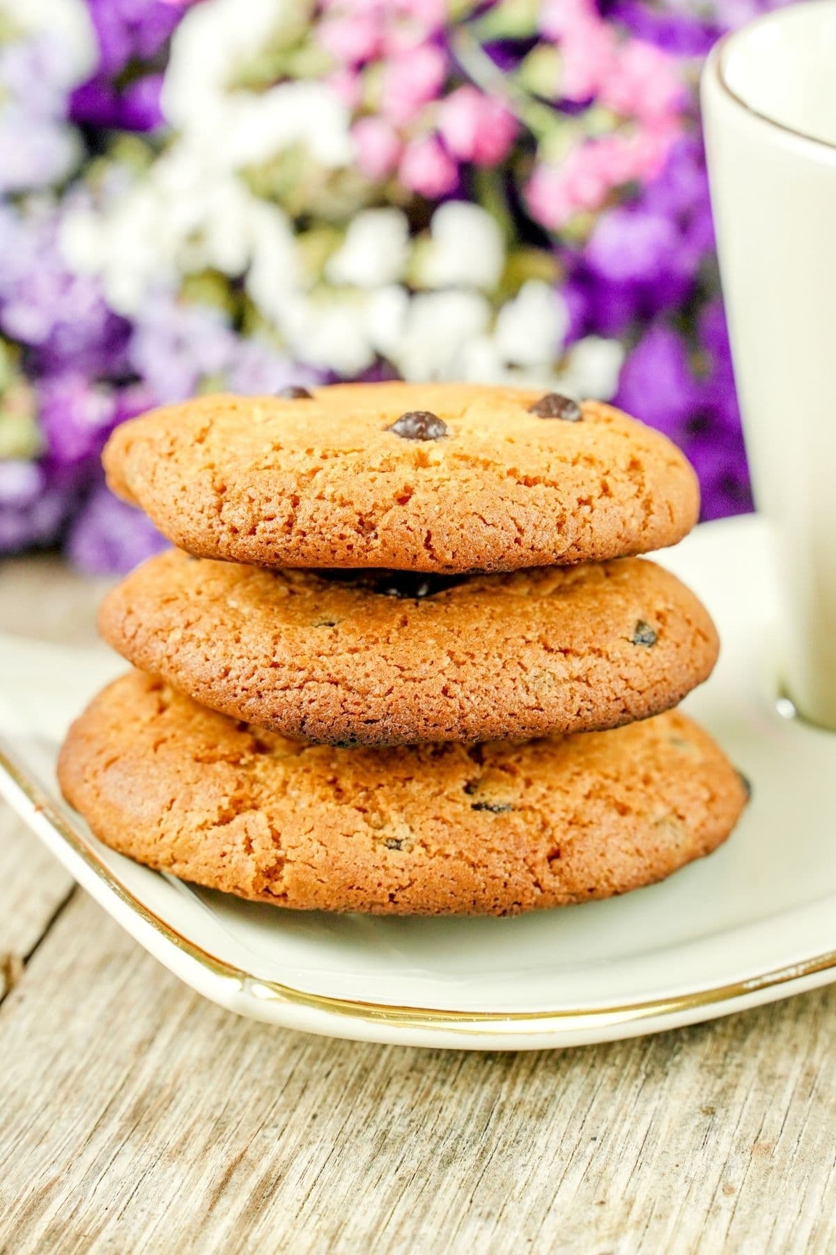 stack of cookies on white plate by purple flowers