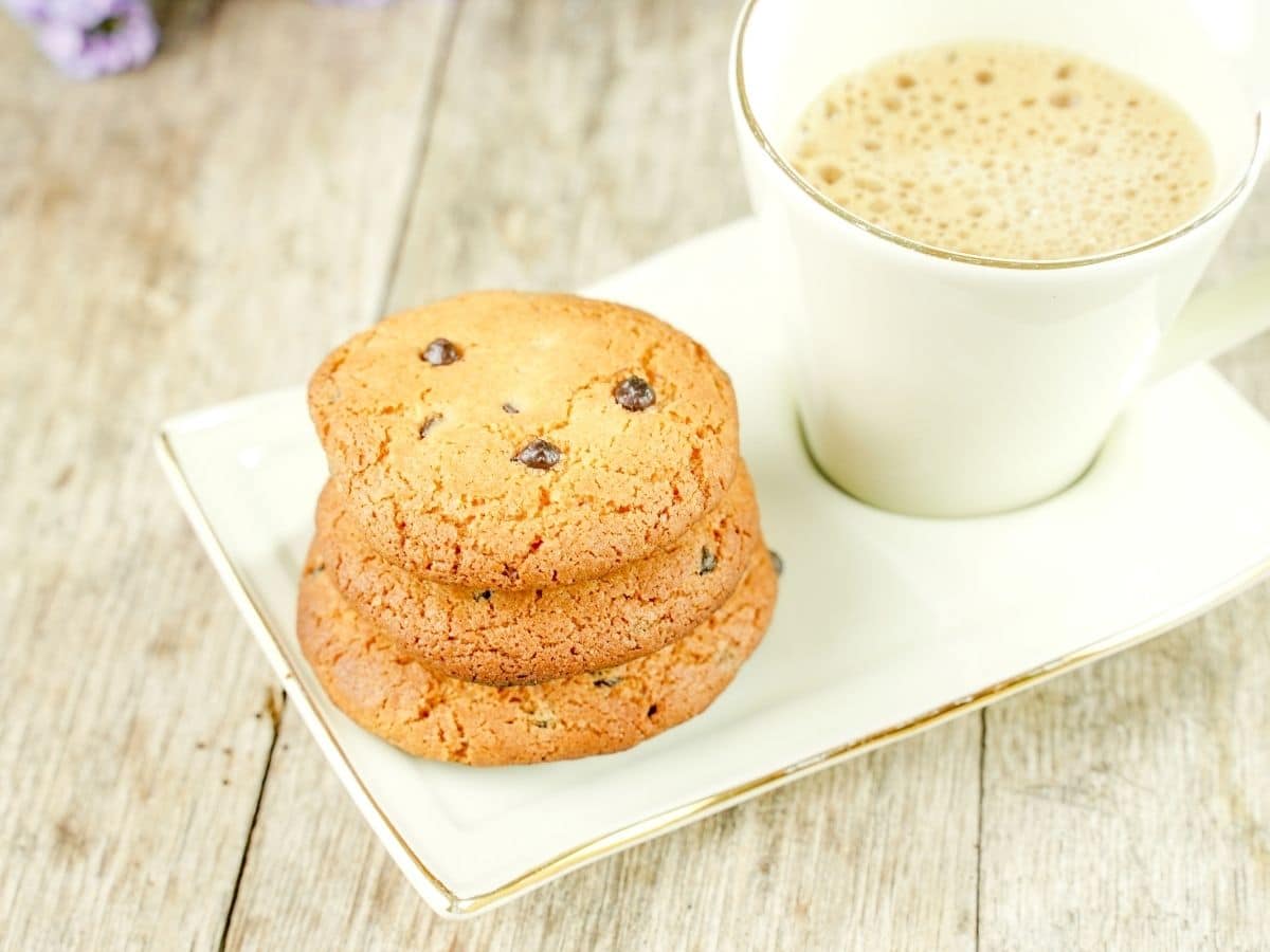 white plate with mug of coffee and cookies on wood table
