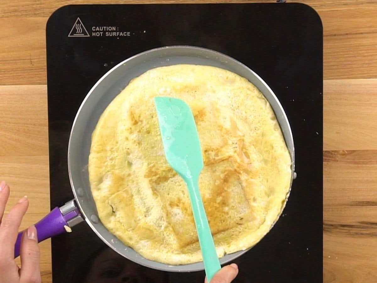 blue spatula flipping egg and toast over