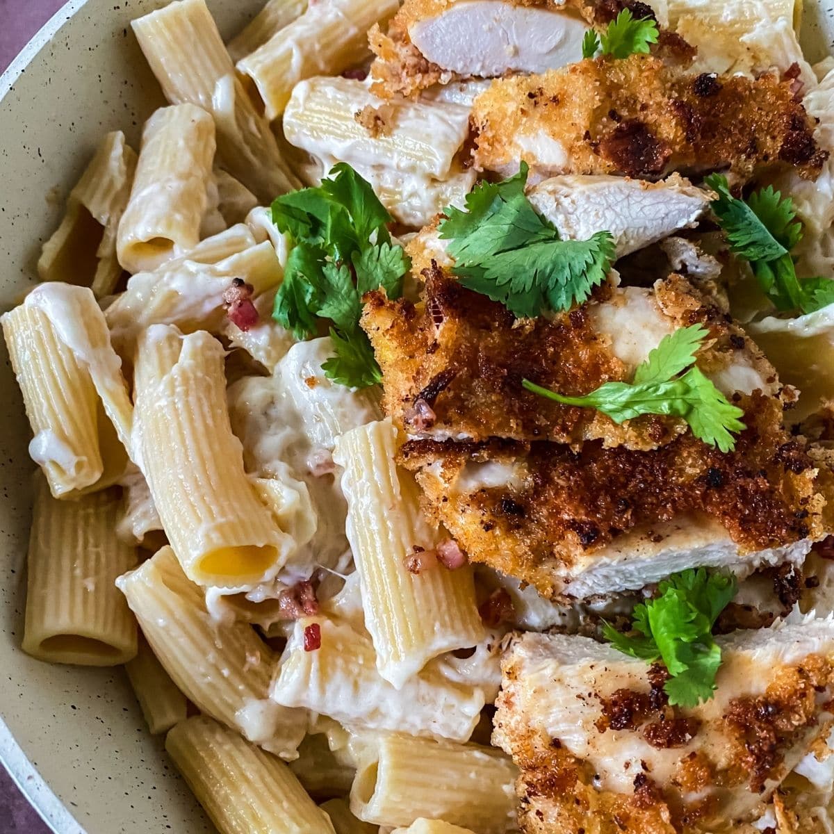 white bowl on wood table filled with chicken cordon bleu pasta