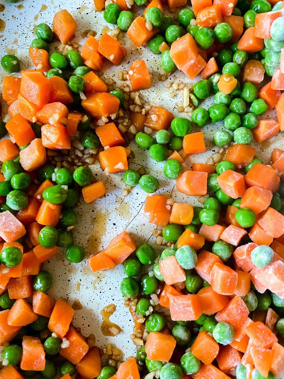 peas carrots and garlic in large skillet