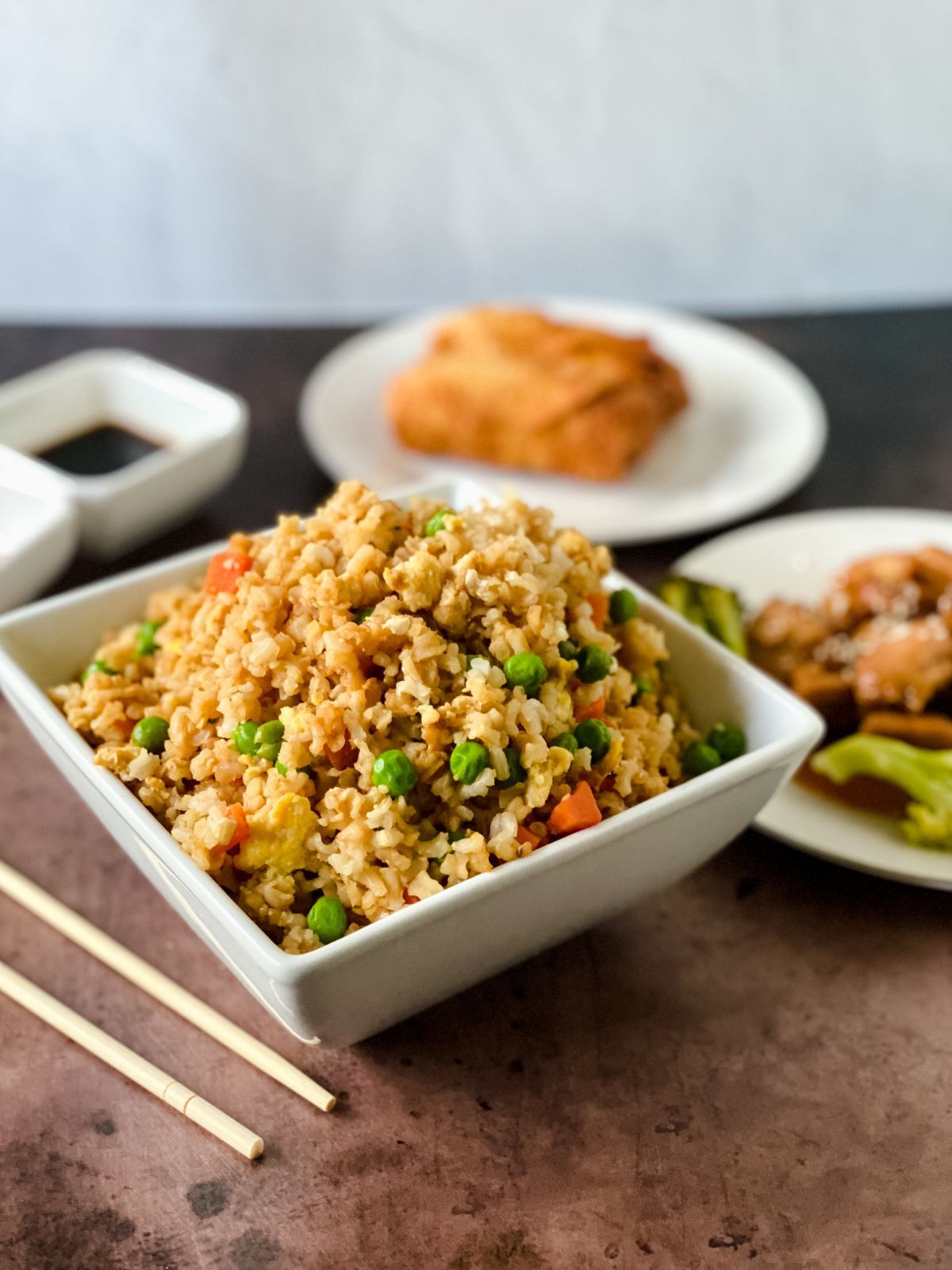 white square bowl of chicken fried rice on wood table