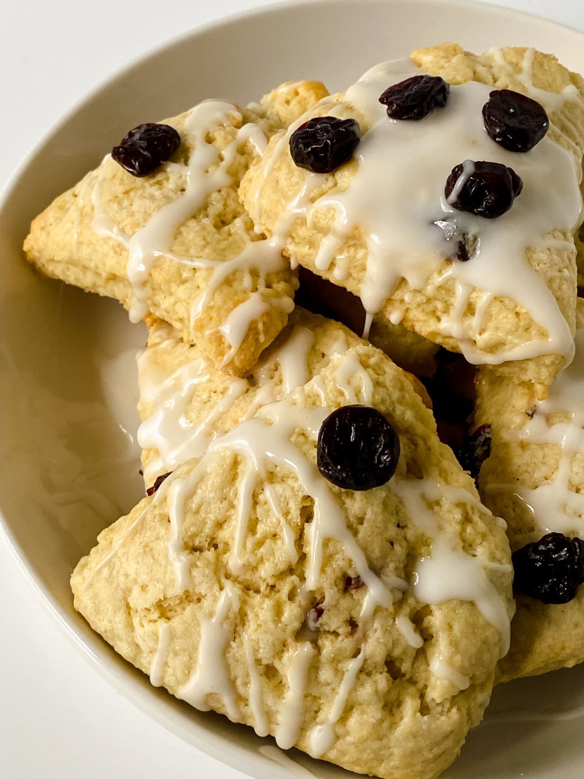 glazed cherry scones with dry cherries on top in large white bowl