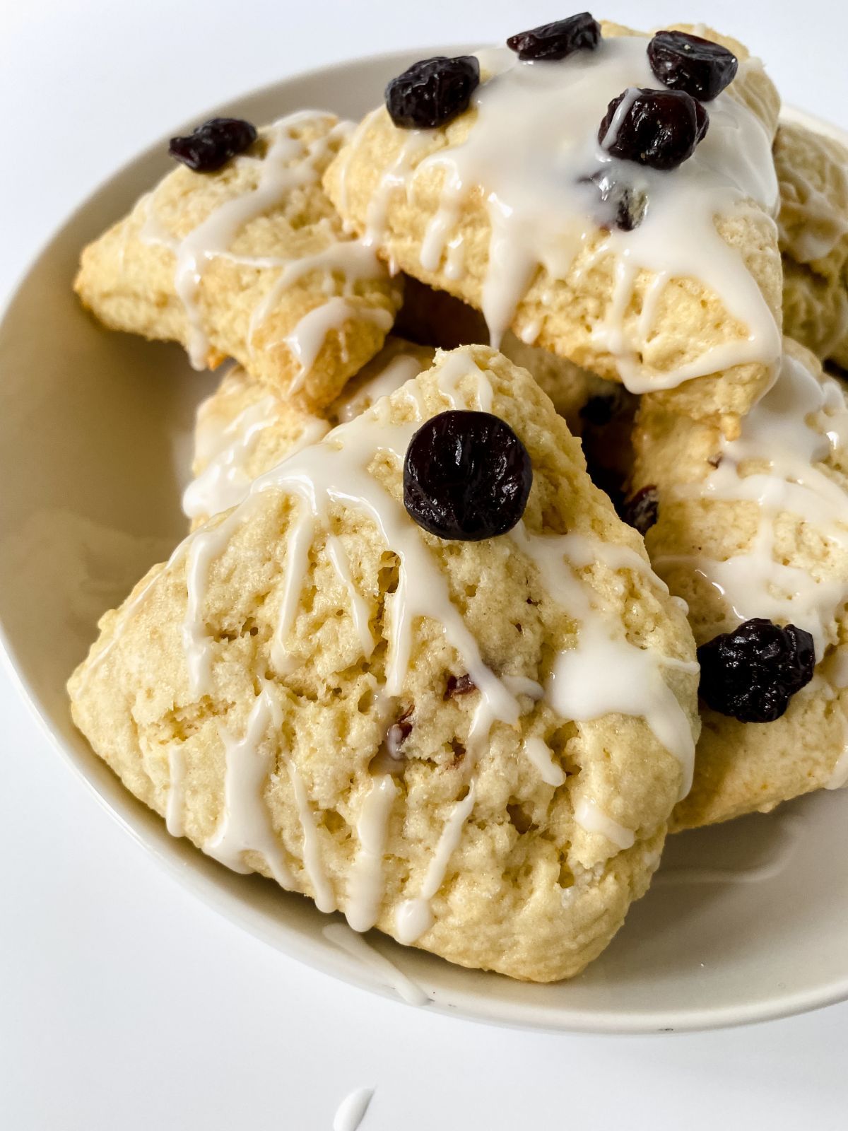 scones in bowls with glaze and dried cherries on top