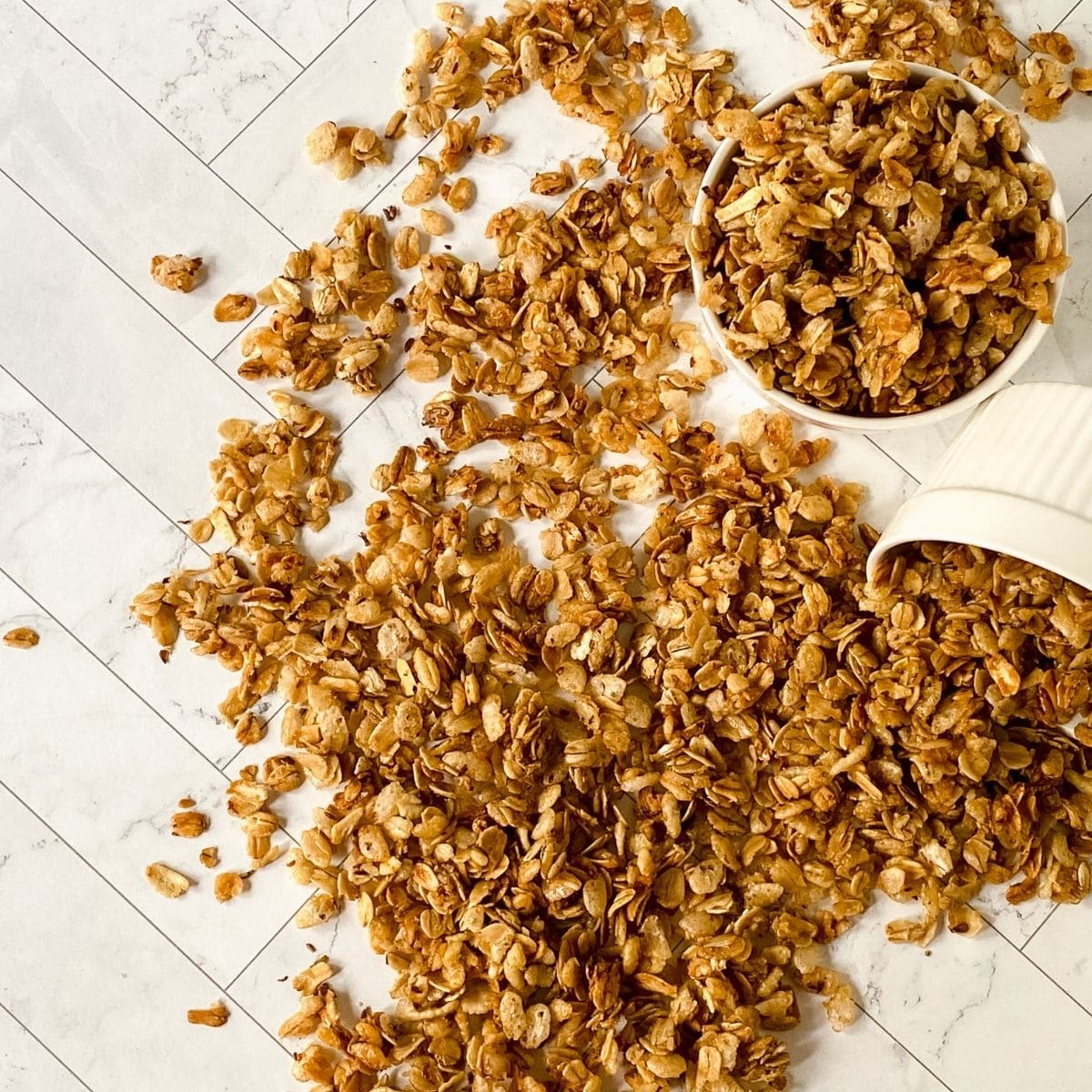 white ramekins of granola with one spilling onto table