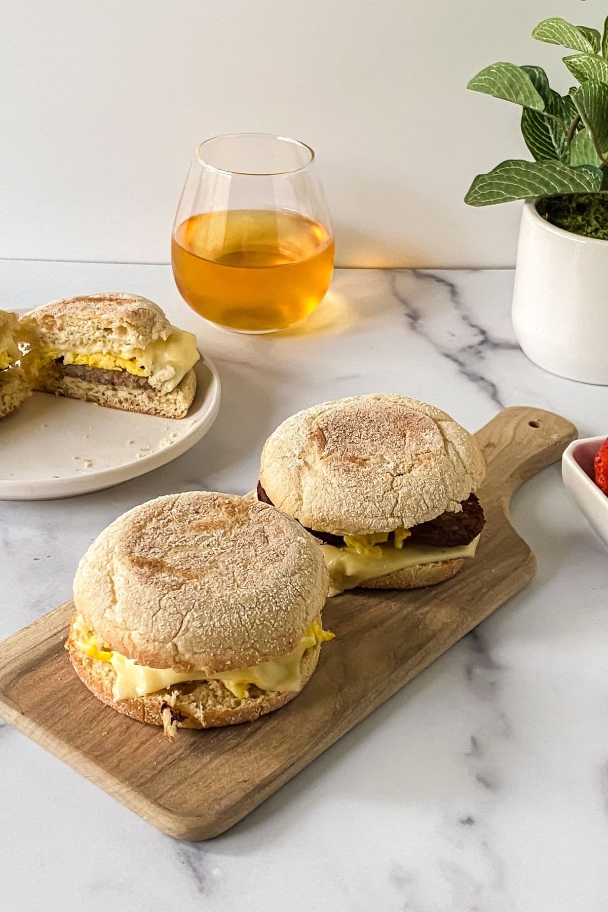 breakfast sandwiches on wood board on marble table