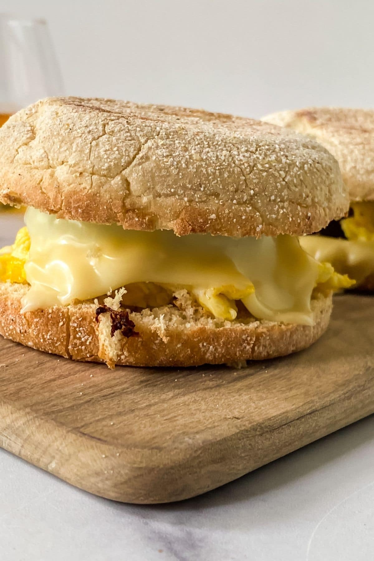 cheesy egg sandwich on wood cutting board