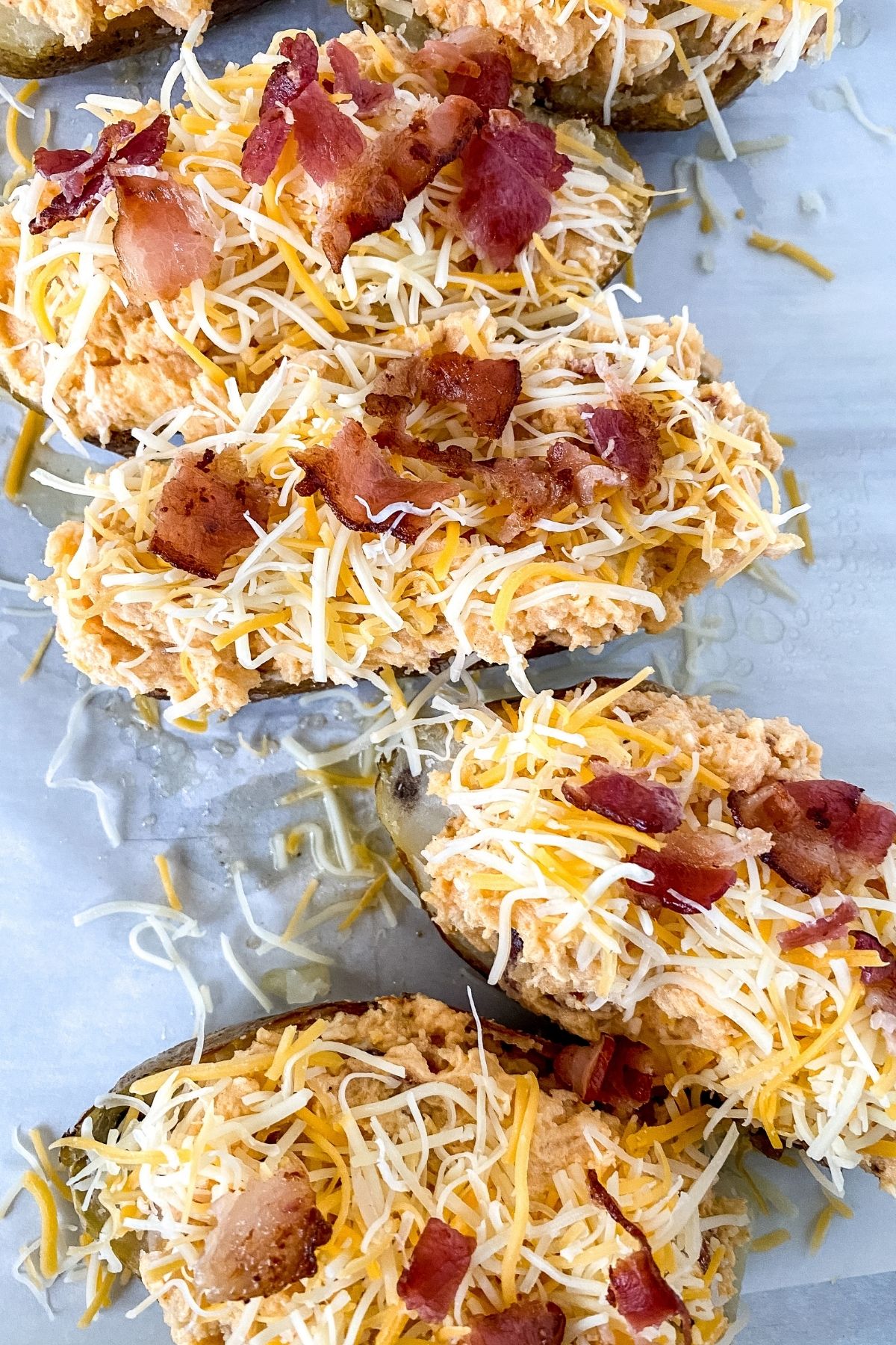 half potatoes topped with shredded cheese and bacon