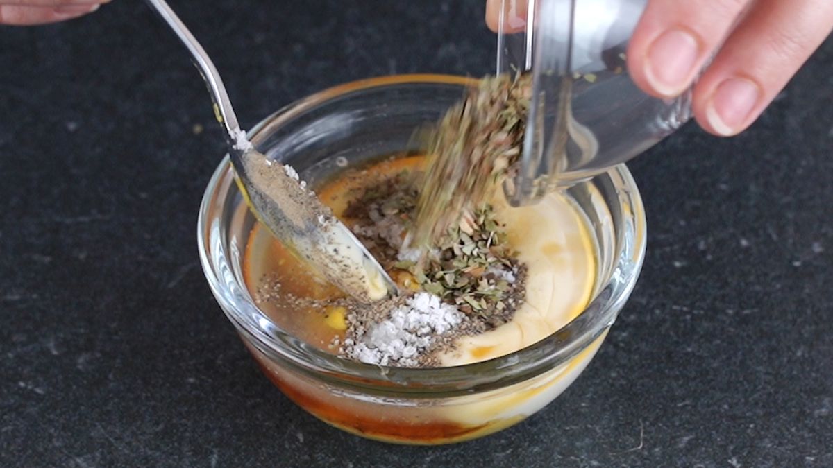 spoon stirring honey mustard in small glass bowl