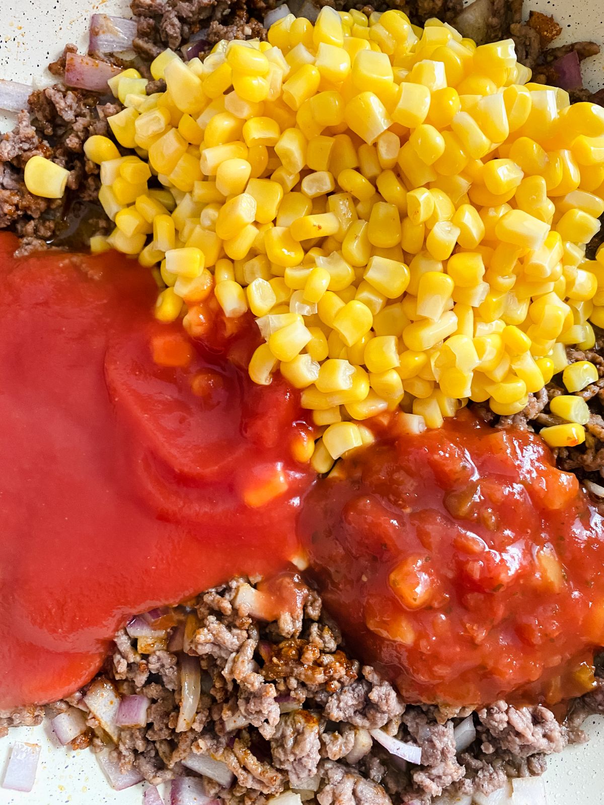 beef tomato sauce corn and salsa in skillet