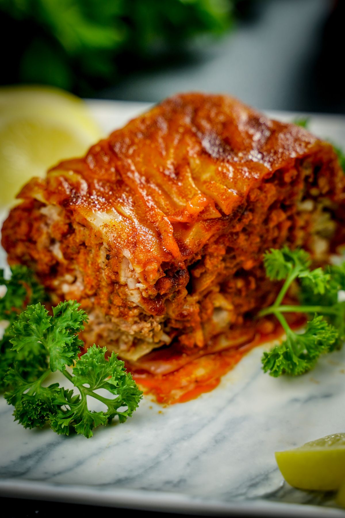 lasagna on marble plate with parsley