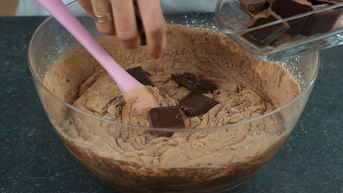 pink spatula in glass bowl of brownie batter